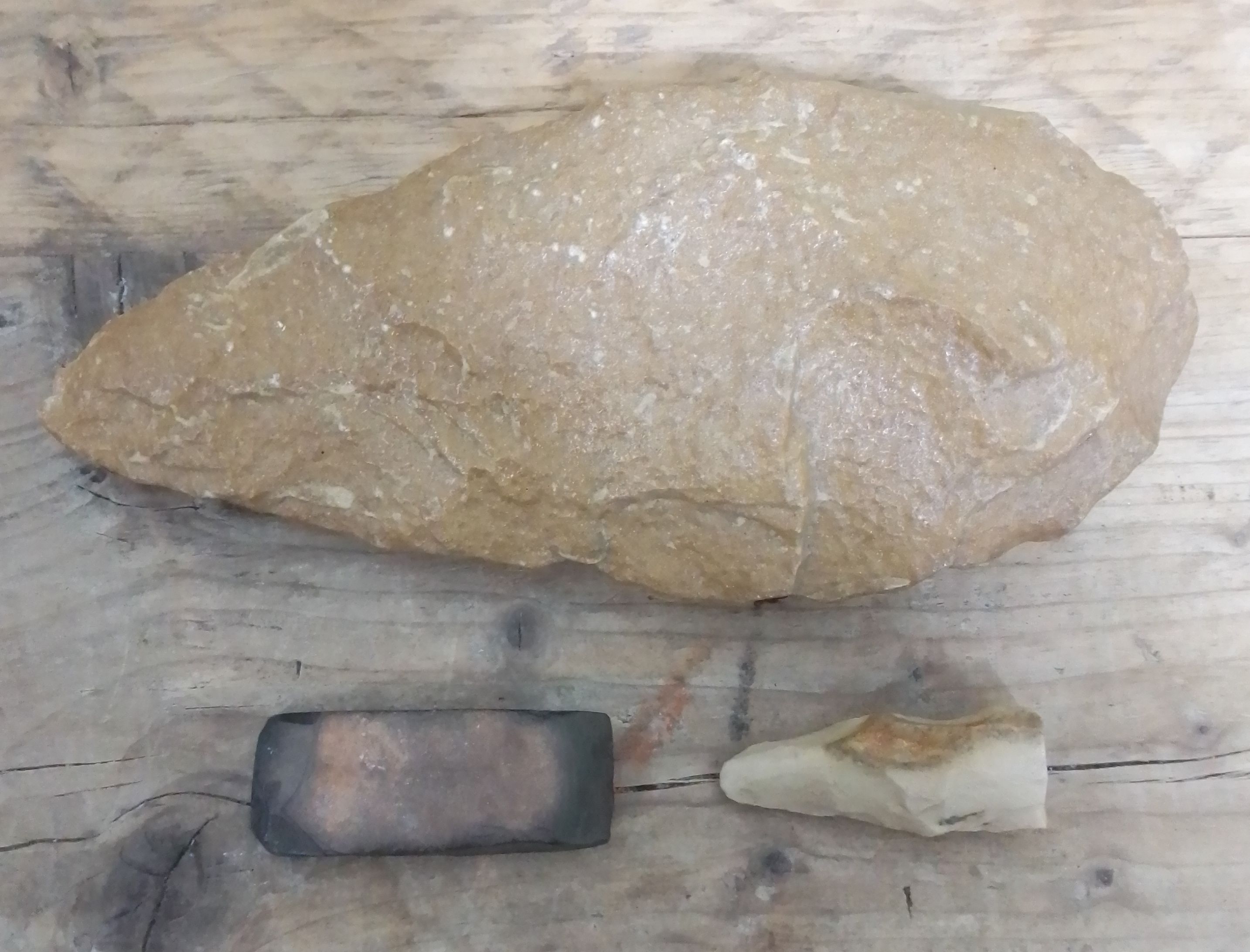 Neolithic stone tools comprising a large axe head, length 22cm, a small polished rectangular axe