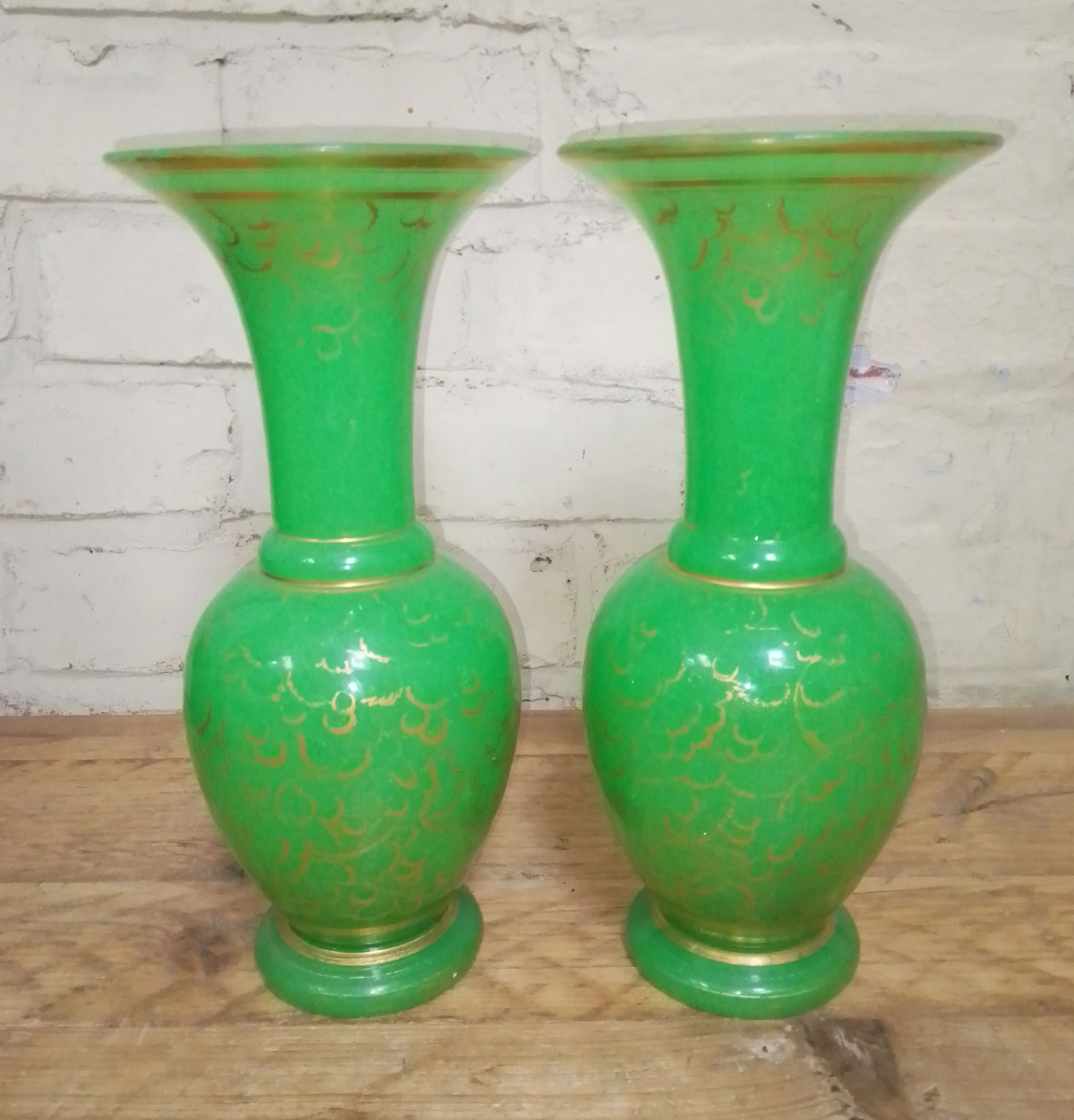 A pair of French 19th century opaline green and gilt glass baluster vases with flared rims, ovoid