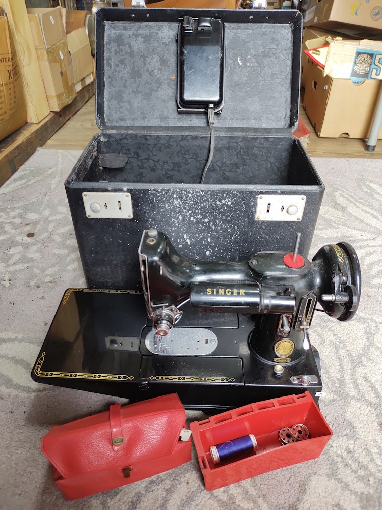 A Singer Featherweight 222K sewing machine with accessories.