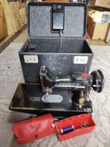 A Singer Featherweight 222K sewing machine with accessories.