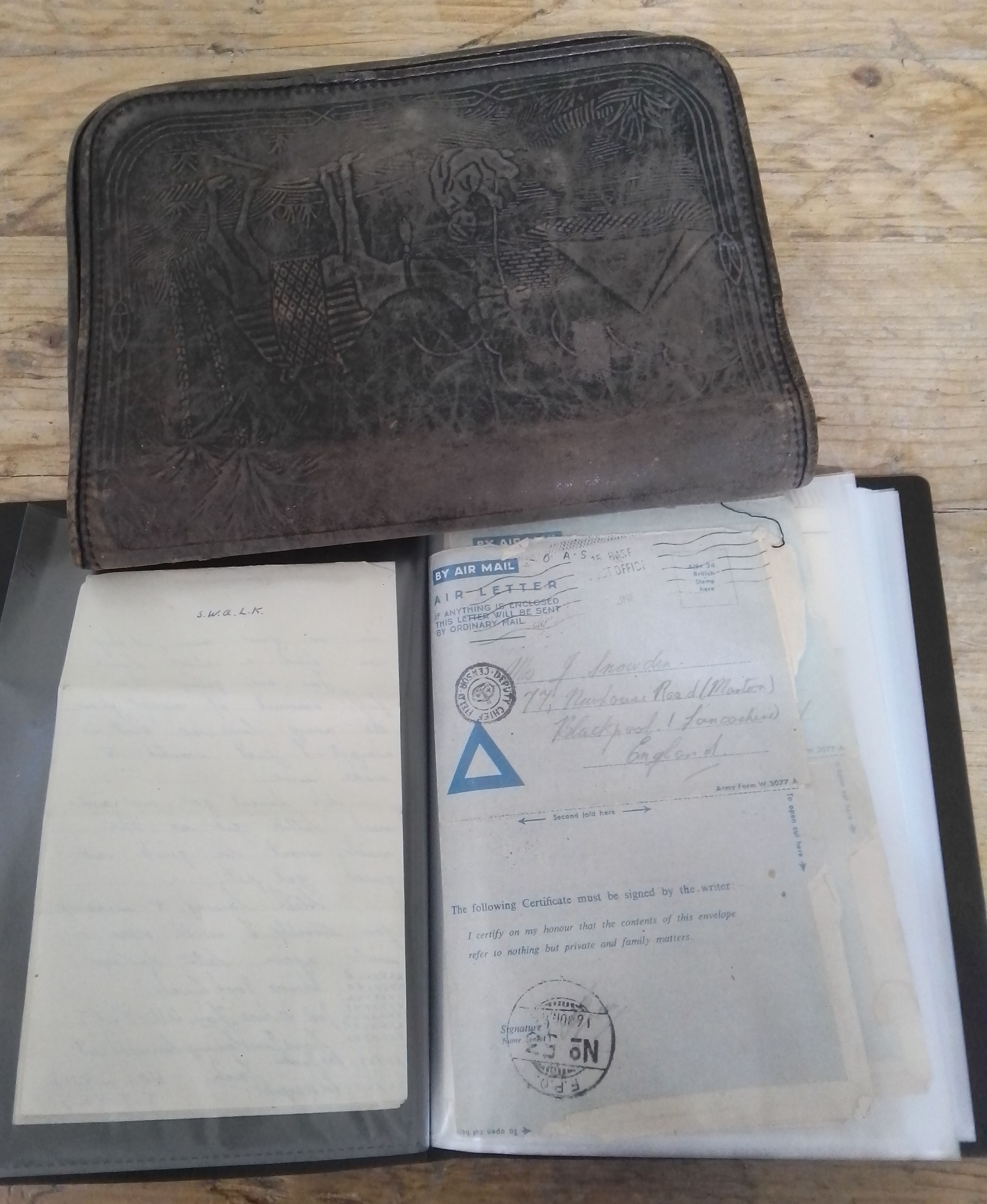 A leather wallet from the Middle East containing WWII ephemera including letters, photographs,
