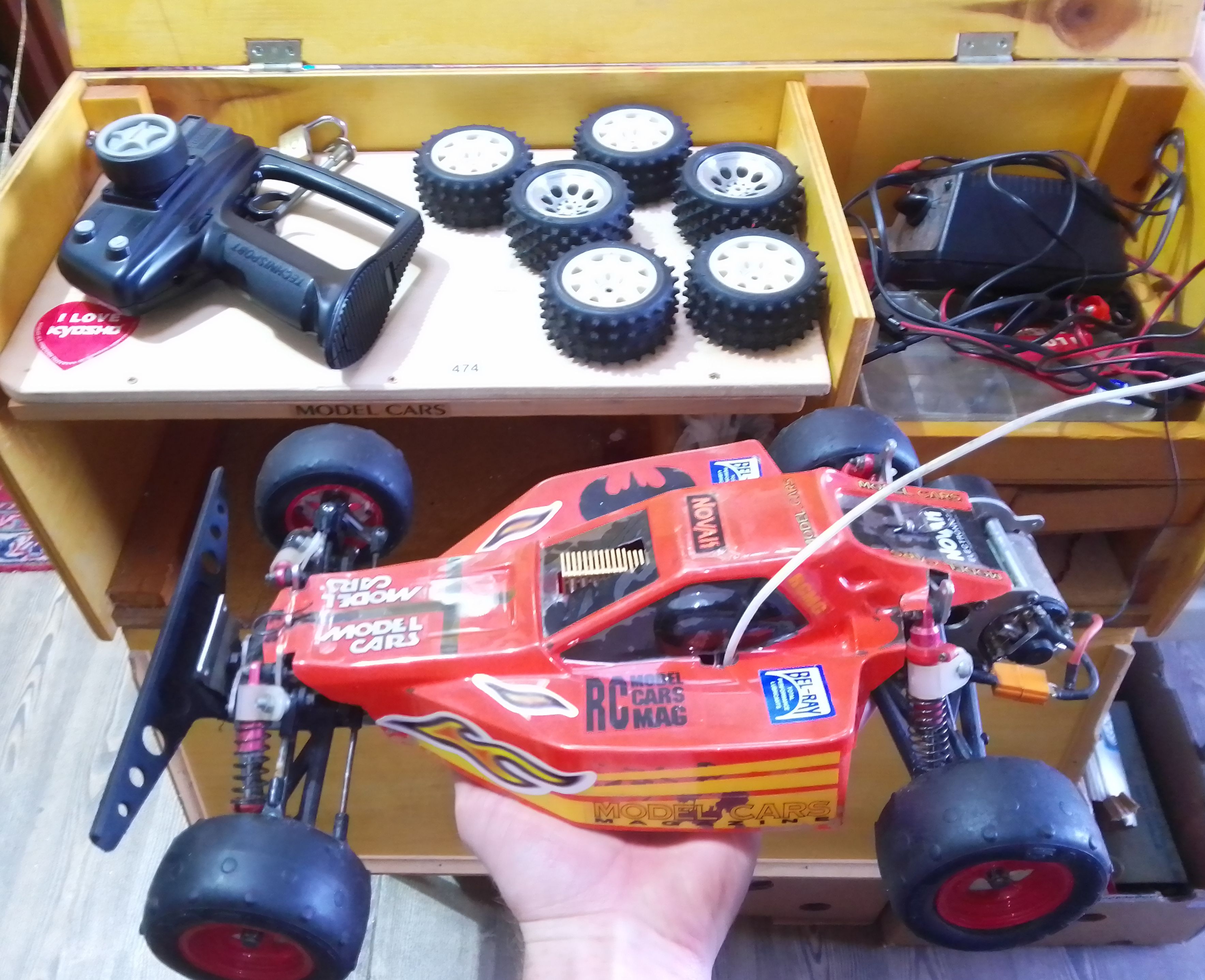 A Tamiya Orange Crush RC model car with wooden case and accessories.