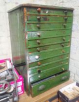 A large green horologist's chest and contents comprising watch and clock making spares.
