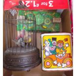 Three vintage toys comprising a singing bird automaton, a jack in the box and a town with wind