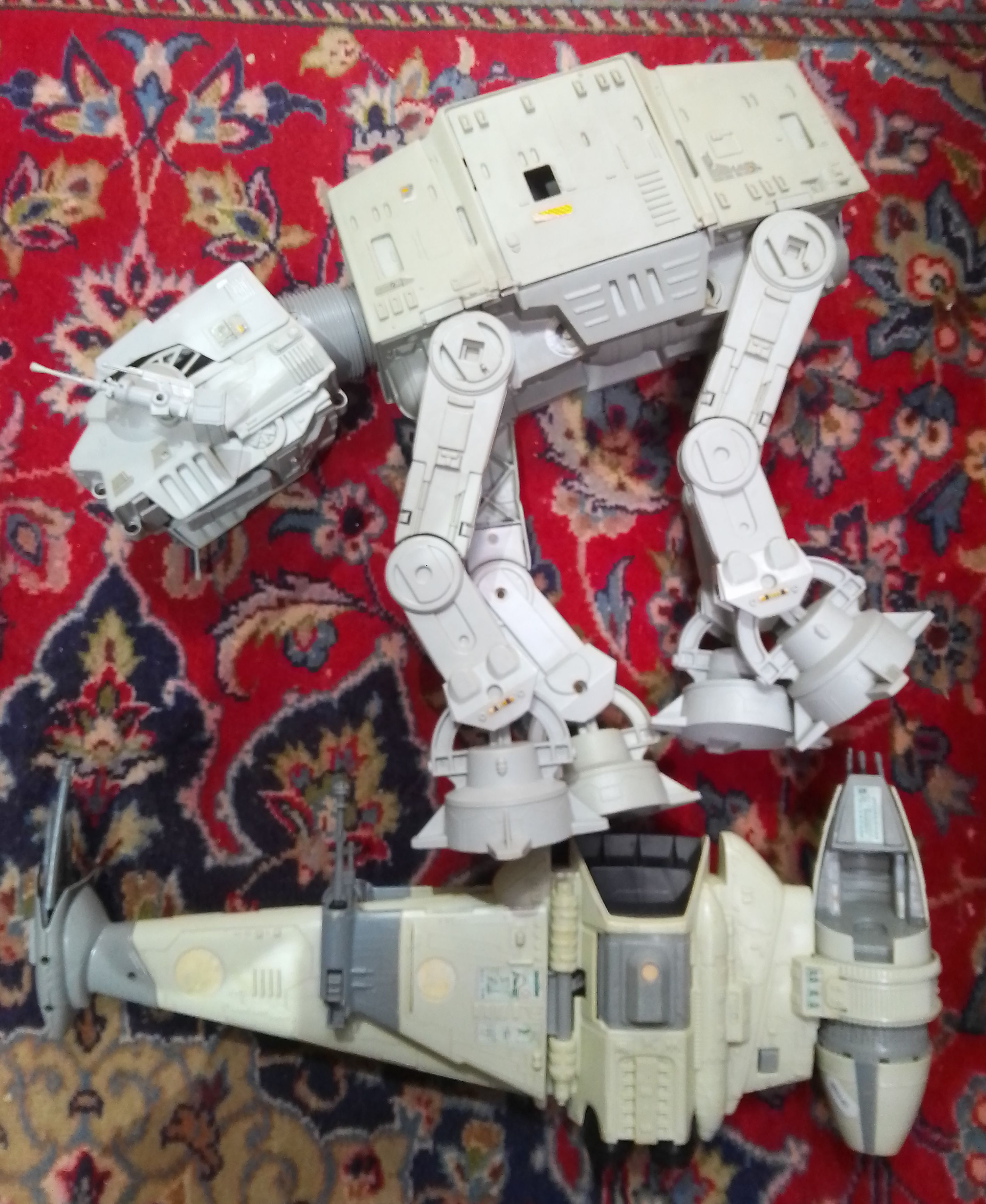 Two vintage Star Wars toys; an AT-AT and a B-Wing Fighter.