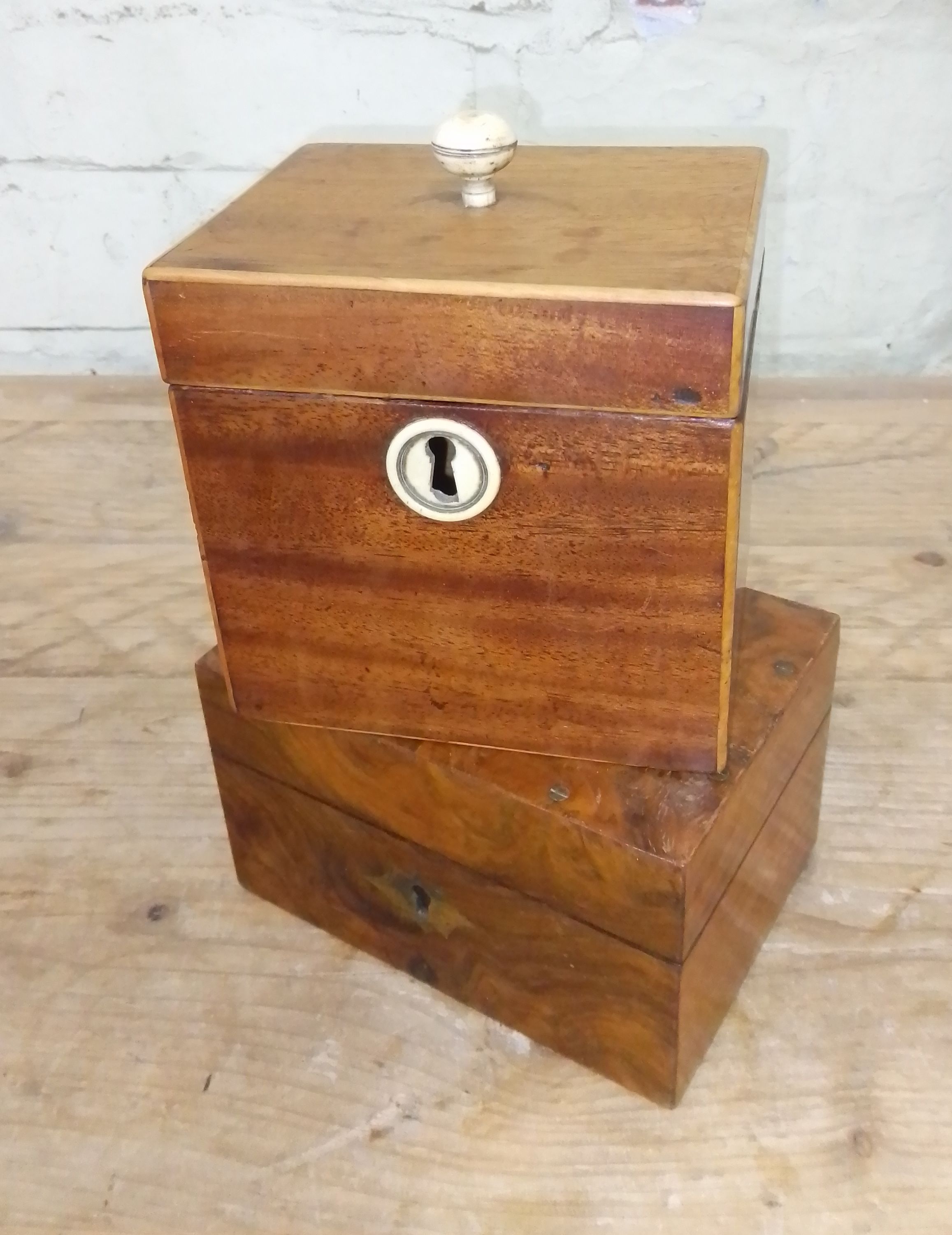 A 19th century mahogany tea caddy with bone finial and escutcheon, together with another box.