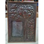 An Arts & Crafts copper picture frame decorated with birds, fruit tree and flowers.