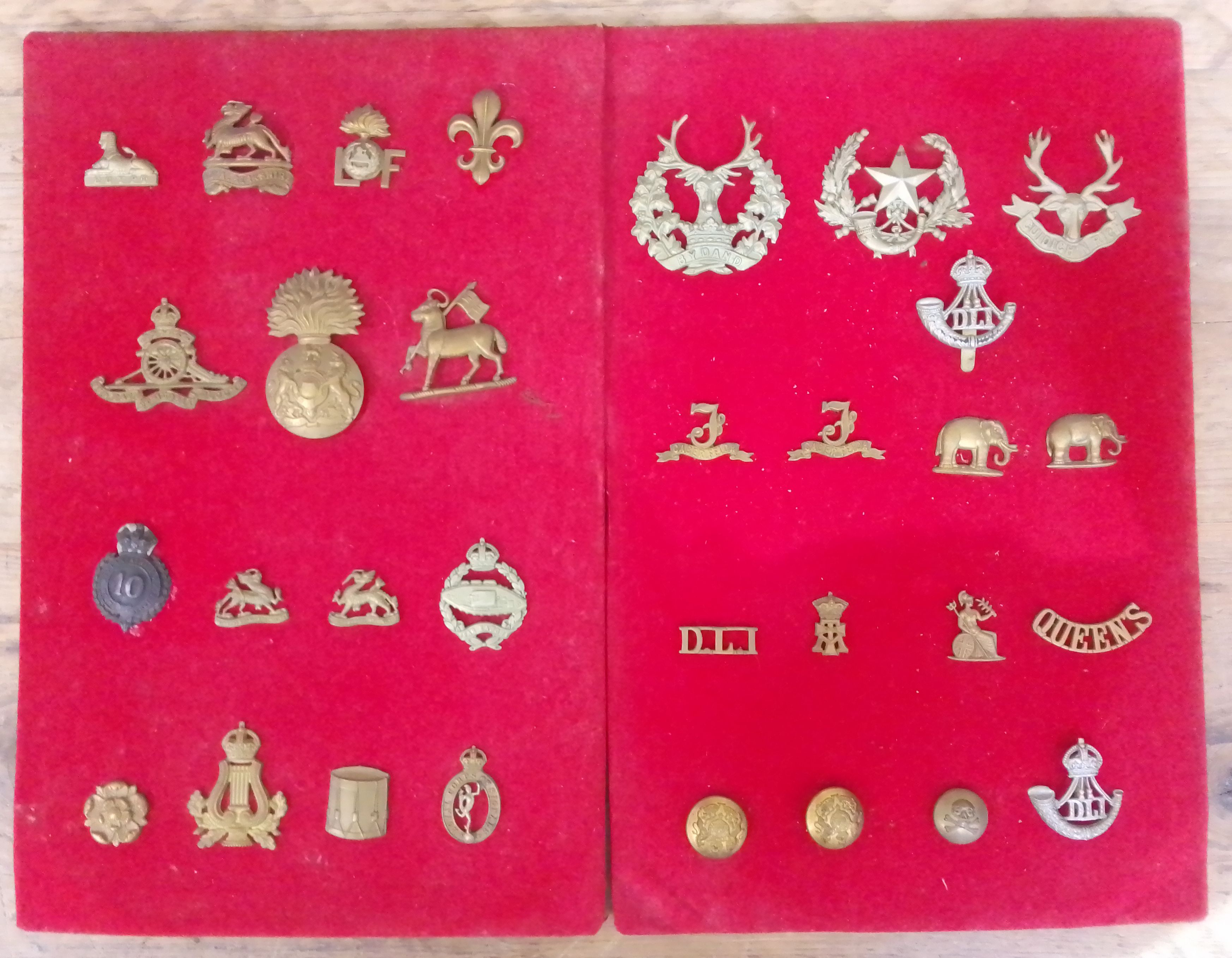 A collection of 31 military cap badges and buttons.