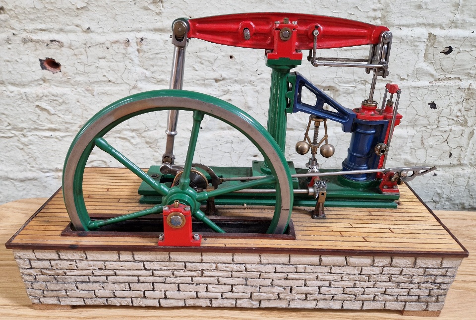 A well engineered model of a live steam beam stationary engine on simulated stone base, size of base