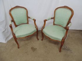 Pair of French style open armchairs with foliate carved frames and cabriole supports, padded green