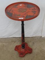 Oriental style red and black lacquered occasional table decorated with figures in a landscape to the