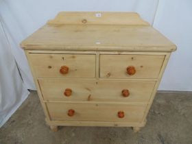 Victorian pine chest of two short and two long drawers with raised back, standing on turned feet -
