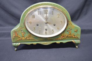 Green painted chinoiserie mantel clock with oval silvered dial and brass numerals, standing on