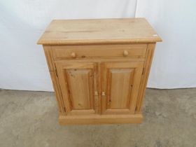 Pine side cabinet having single drawer over two panelled cupboard doors opening to reveal a single