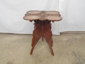 Hardwood carved folding occasional table having carved foliate and floral lily pad decoration to the