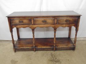 20th century oak dresser base having three short drawers over shaped frieze, the four turned and two