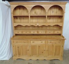 Large 20th century pine dresser the rectangular pediment having three arches below with a two tier