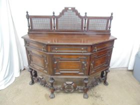 Mahogany sideboard having a triple cane panel back united by turned supports with finials over a