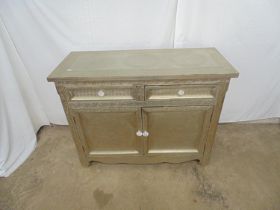 20th century wood and metal embossed sideboard having two short panelled drawers over two panelled