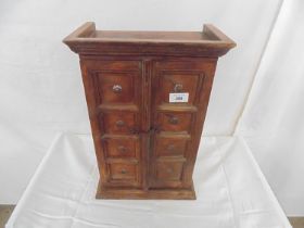 Hardwood table top cabinet the two panelled doors opening to two fixed shelves, standing on