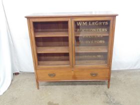 Mahogany glazed two door cabinet the right glazed pane being sign written for WM Legrys