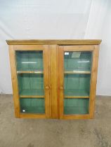 Stained and painted two door glazed wall cabinet the doors opening to reveal a green painted