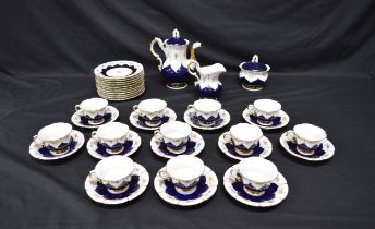 White ground teaset having cobalt blue decoration with panels of flowers and gilt borders, bearing