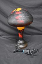 Modern orange and red glass mushroom form table lamp decorated with trees and mountains, bearing the