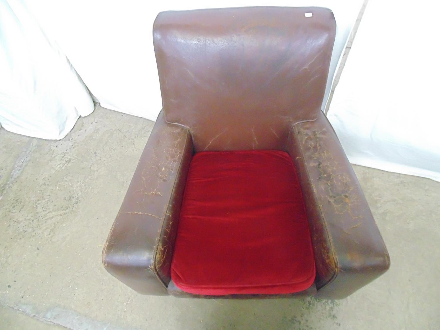 Brown leather club chair with red cushion, standing on block feet and castors (af) - 84cm x 72cm x - Image 2 of 5