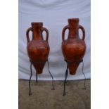 Pair of earthenware two handle urns on metal stands - 84cm and 79cm tall Please note descriptions