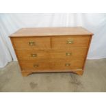 Light oak chest of two short and two long drawers with military style handles, standing on bracket