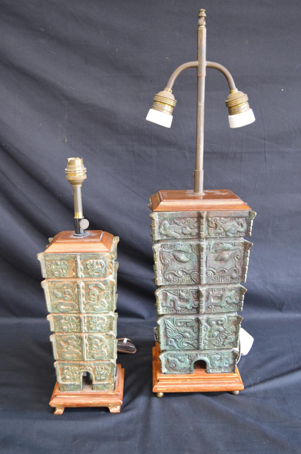 Two bronze 20th century table lamps having adjustable heights, standing on wooden bases Please