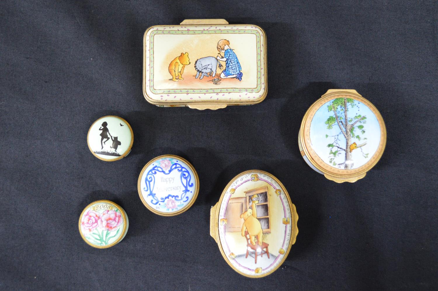 Group of five Halcyon Days enamel trinket boxes (four Winnie the Pooh and floral decorated) together