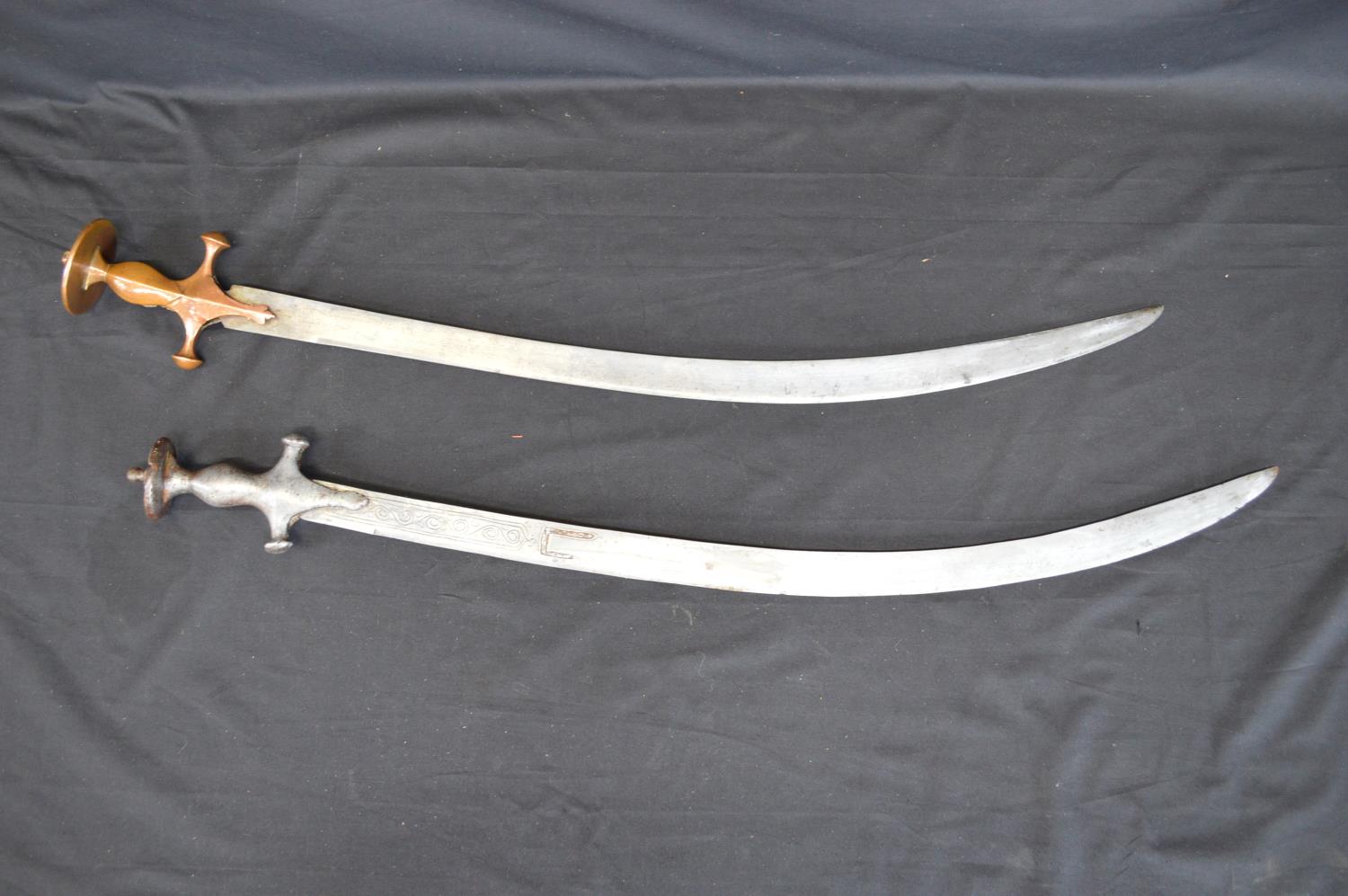 Two Tulwar swords having curved steel blades - 82.5cm x 84cm long Please note descriptions are not