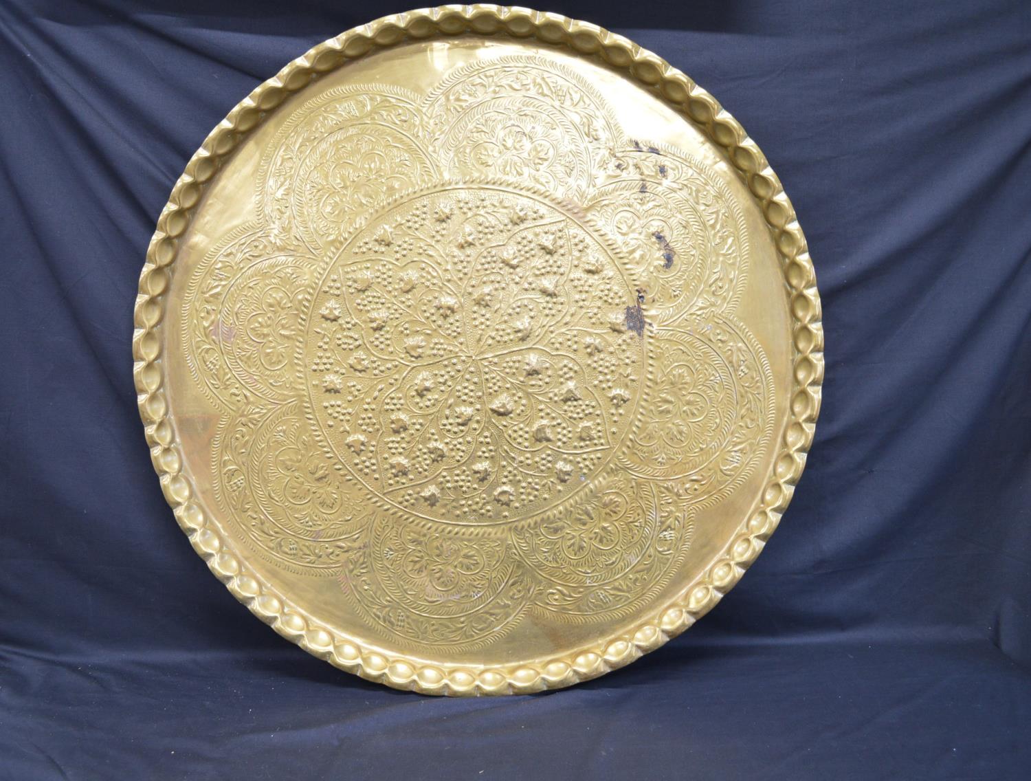 Large circular brass tray with decorative embossed decoration - 89cm dia Please note descriptions