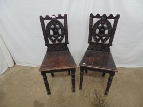 Pair of oak hall chairs having carved backs, solid seats and turned front legs - 42cm x 38cm x