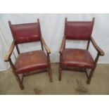 Pair of oak elbow chairs having red leather padded backs and seat with studwork detail, standing