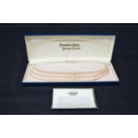 Pompadour simulated pearl necklace formed of three strings, in original box Please note descriptions