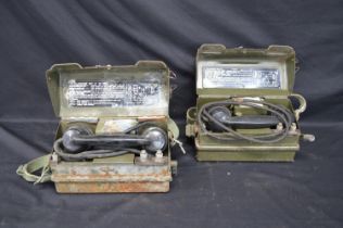 Two British Army field telephones each numbered YA 7815 with broad arrow and having woven shoulder