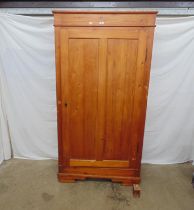 Pine cupboard having a single panelled door opening to three fixed shelves (one broken) and standing
