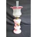 Pink glass oil lamp with hand painted decoration of butterfly and flowers having frosted and red