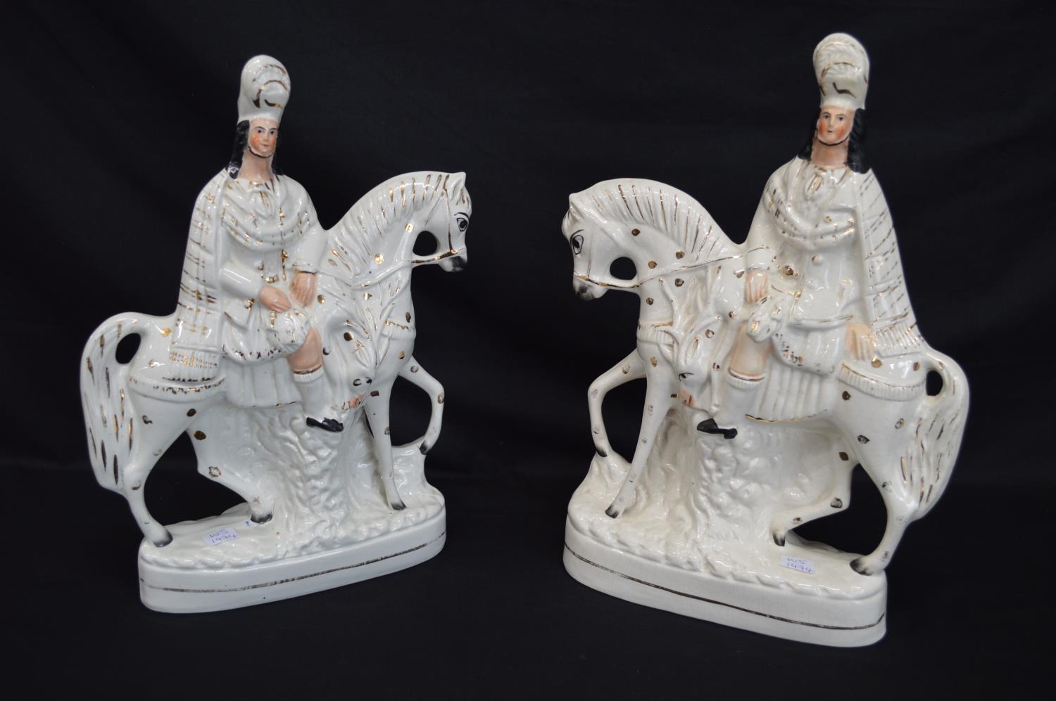 Pair of Staffordshire figures of Scottish Highlander Huntsmen on horseback with gilt highlights,