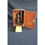 20th century brass microscope marked EP Quinn, Manchester, housed in a mahogany case with top