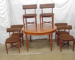 Mid century teak G Plan circular extending dining table having a single fold out leaf and standing