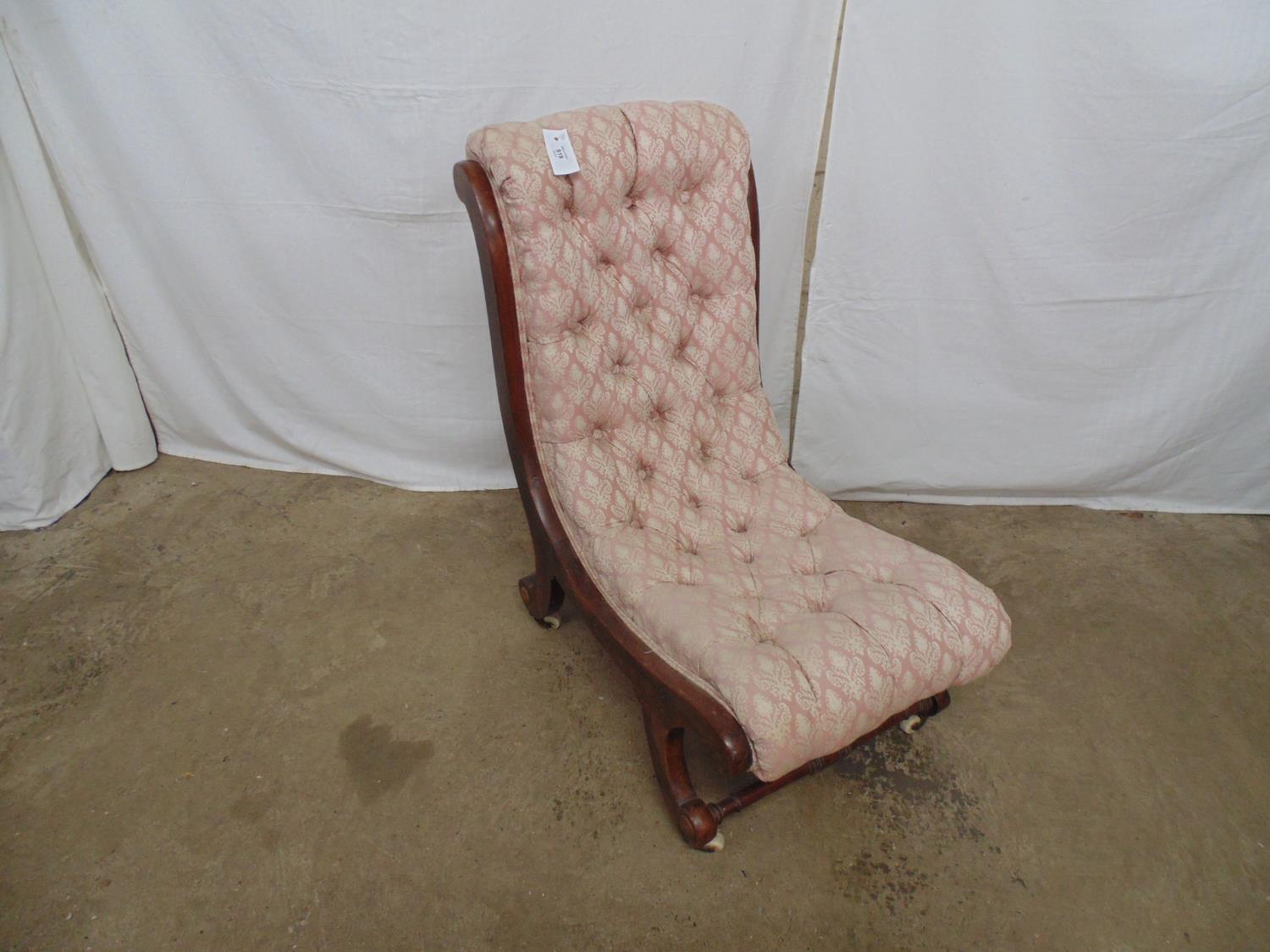 Mahogany slipper chair having buttoned pink and white upholstery, standing on scrolled legs ending