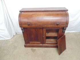 Mahogany cylinder desk the top opening to reveal fitted interior of pigeon holes over two panelled