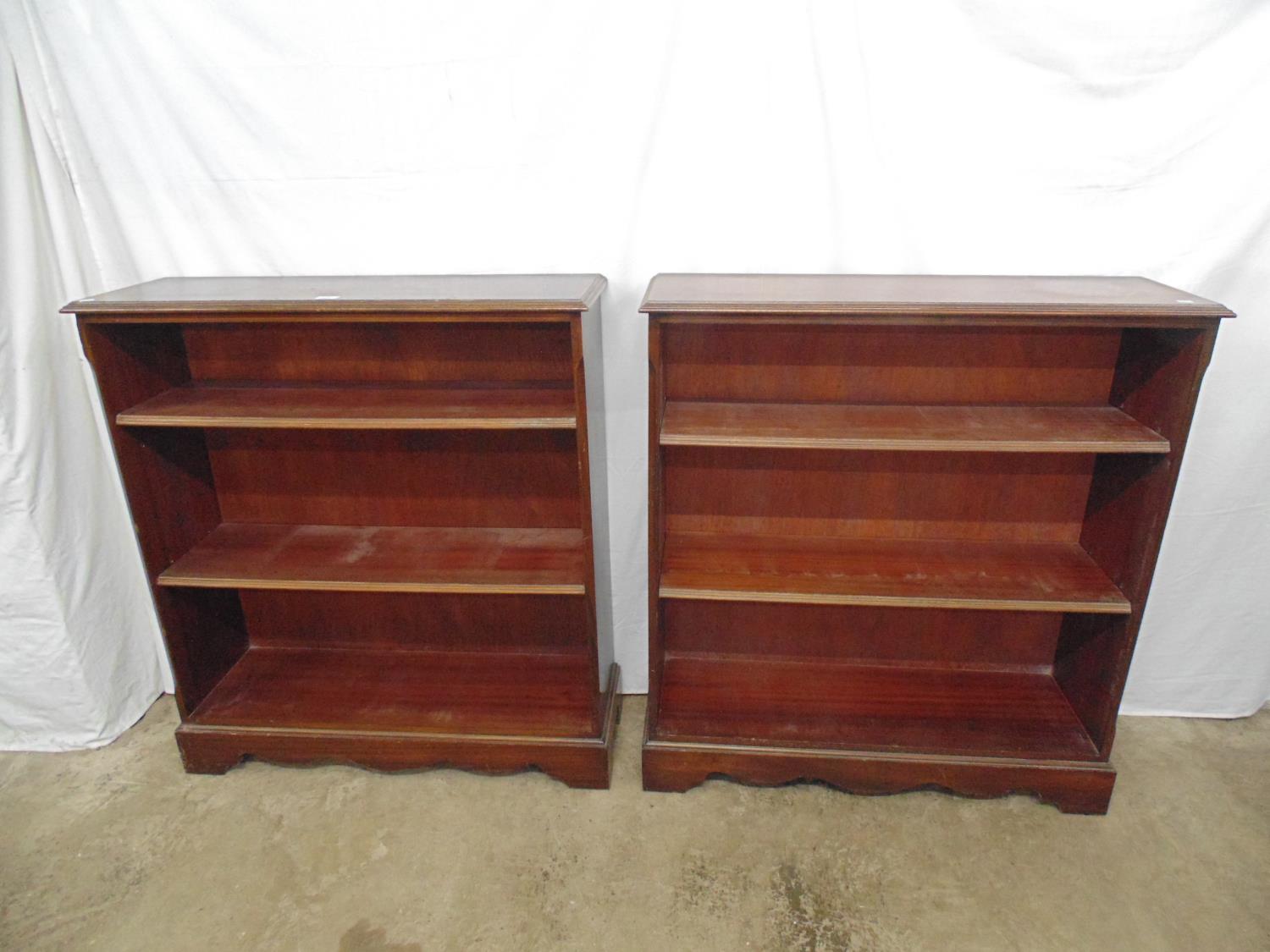 Reproduction mahogany open bookshelves with two adjustable shelves, standing on bracket feet -