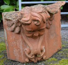 Terracotta corner stone in the form of a cherubs head - 43cm x 35cm tall Please note descriptions