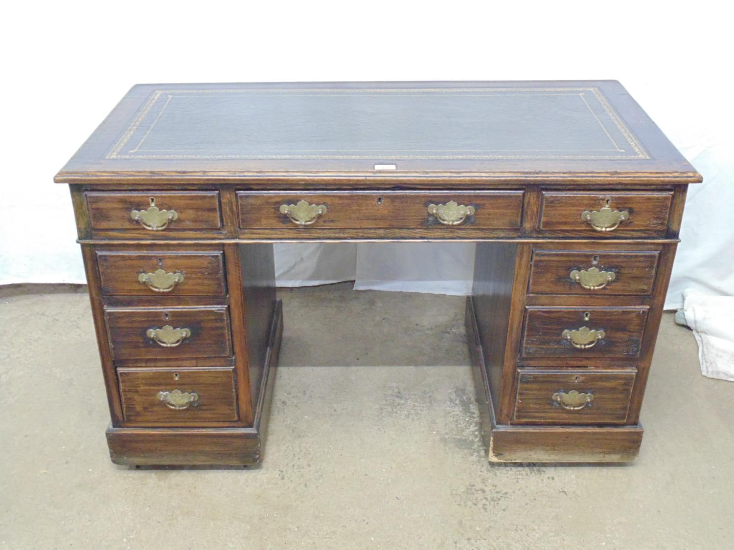 Oak twin pedestal desk having gilt tooled green leather inset top with an arrangement of nine