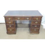 Oak twin pedestal desk having gilt tooled green leather inset top with an arrangement of nine